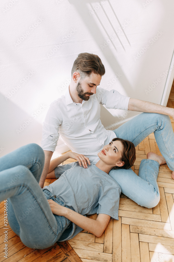 Stylish couple on the bed. Beautiful love story in the dark interior of the Studio. Stylish couple on the bed. Beautiful love story in the dark interior of the Studio.