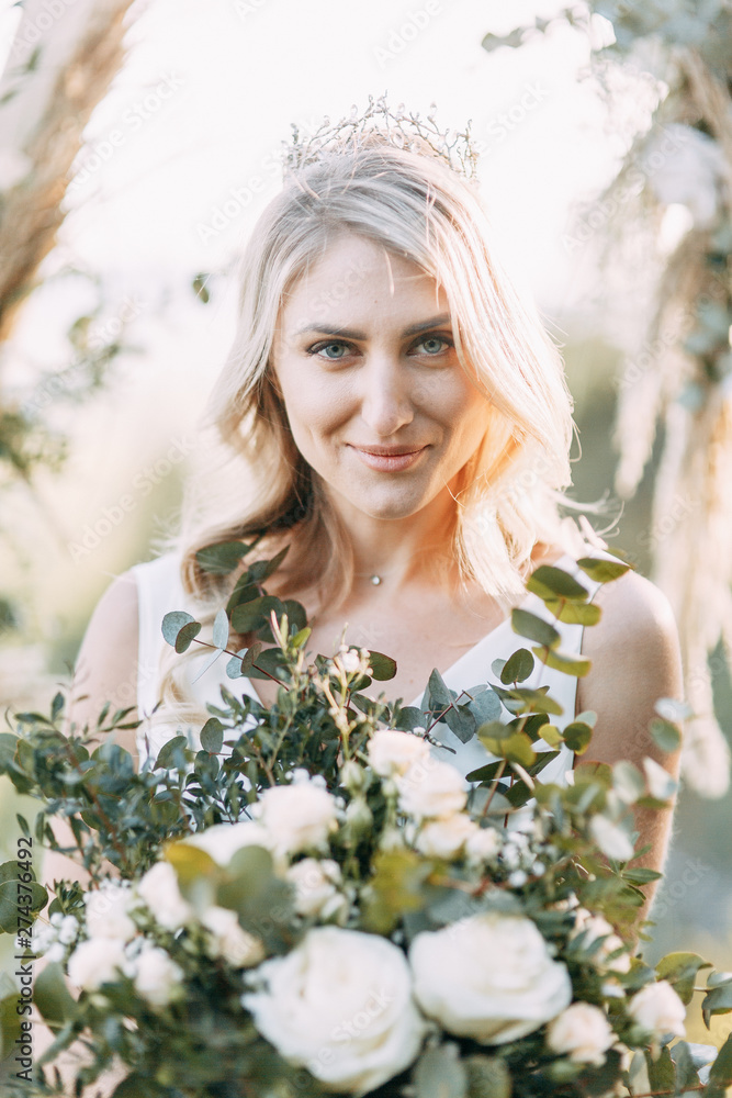 Stylish couple at sunset. Wedding ceremony with a triangular arch.