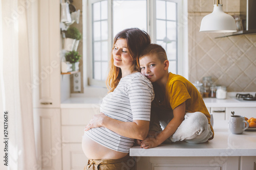 Pregnant mom with kid playing together in the kitchen