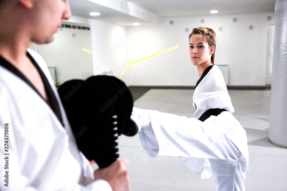 Fototapeta premium Young cute girl with physical disability focused on kicking technique