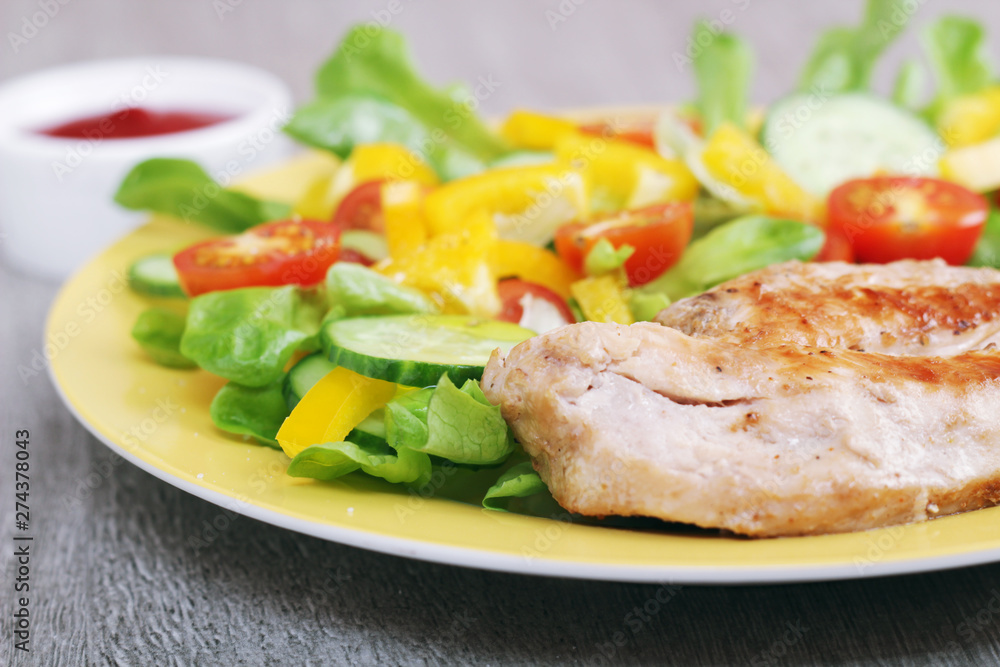 Grilled chicken breast with raw vegetables salad