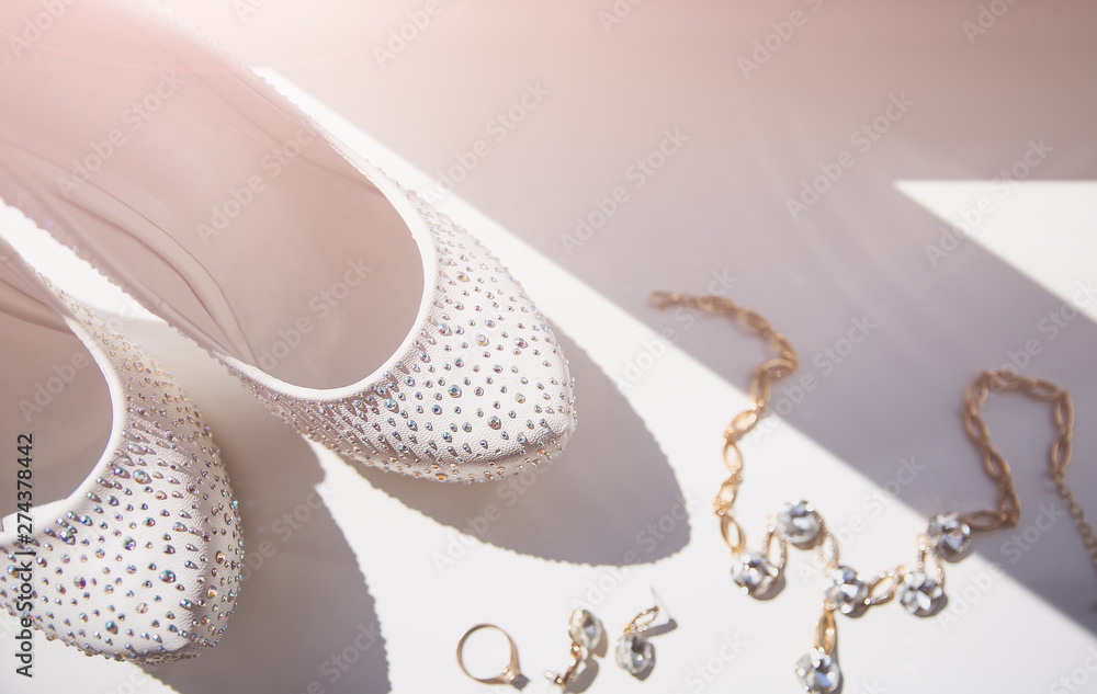 Fototapeta premium Bride's shoes with diamond crystals. Perfumes and earrings accessories. Wedding day photo.