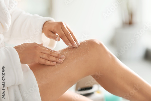 Fotografie, Obraz Beautiful young woman applying body scrub at home, closeup