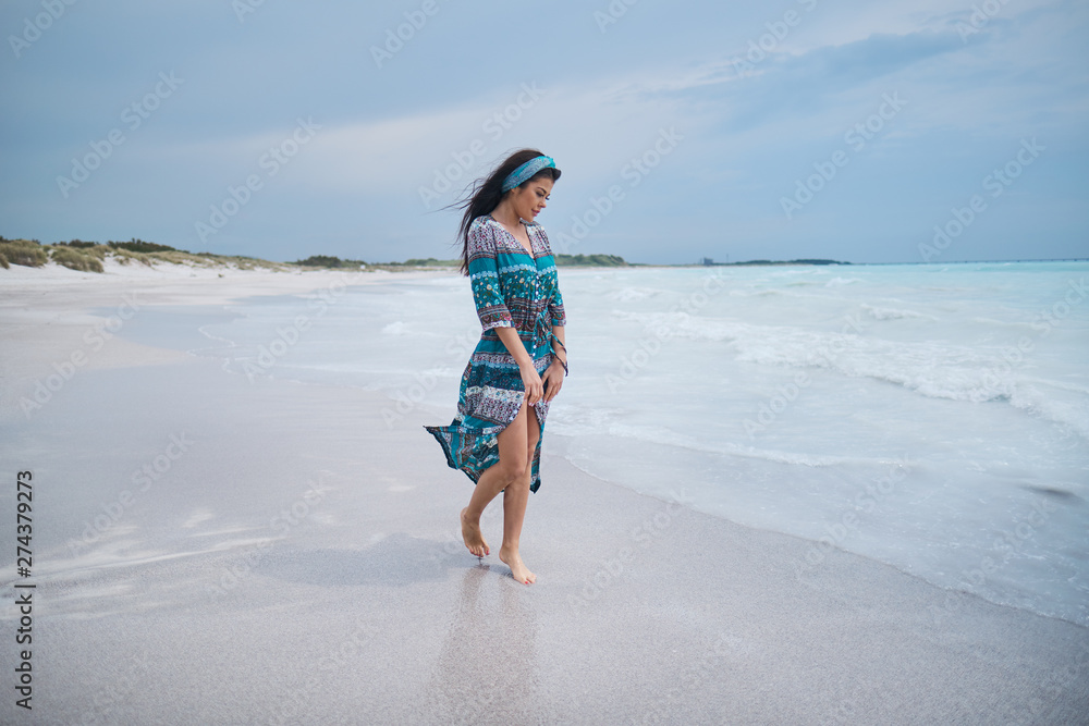 woman in the beautiful dress. walking on the beach
