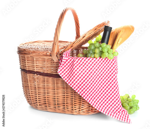 Wicker basket with tasty food and drink for picnic on white background