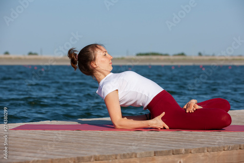 The girl is engaged in meditation on coast of lake