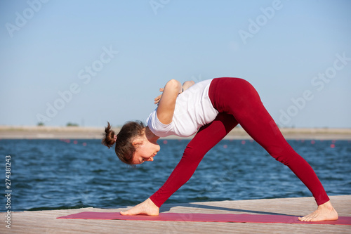 Pilates yoga workout exercise outdoor in the lake pier