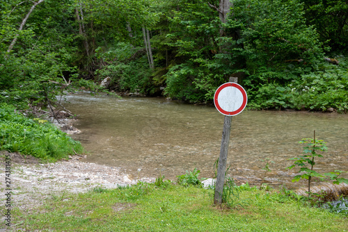 warning sign next to river