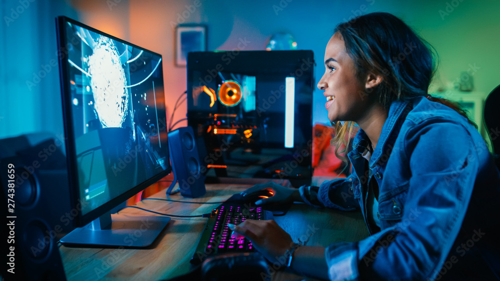 Beautiful and Excited Black Gamer Girl is Playing First-Person Shooter Online Video Game on Her Computer. Room and PC have GreenNeon Led Lights. Cozy Evening at Home. Beautiful and Excited Black Gamer Girl is Playing First-Person Shooter Online Video Game on Her Computer. Room and PC have GreenNeon Led Lights. Cozy Evening at Home.