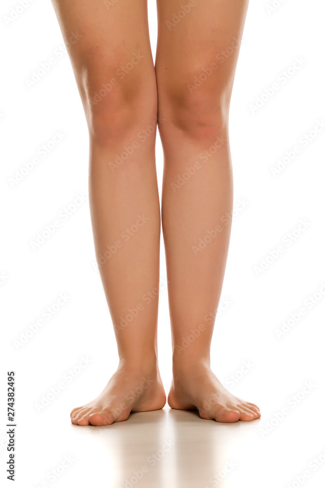 Front view of female barefoot legs on white background Front view of female barefoot legs on white background