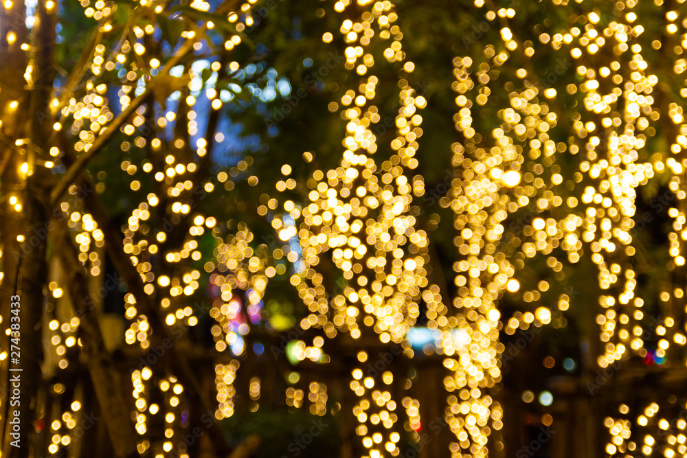 Blurred Decorative outdoor string lights hanging on tree in the garden at night time Blurred Decorative outdoor string lights hanging on tree in the garden at night time
