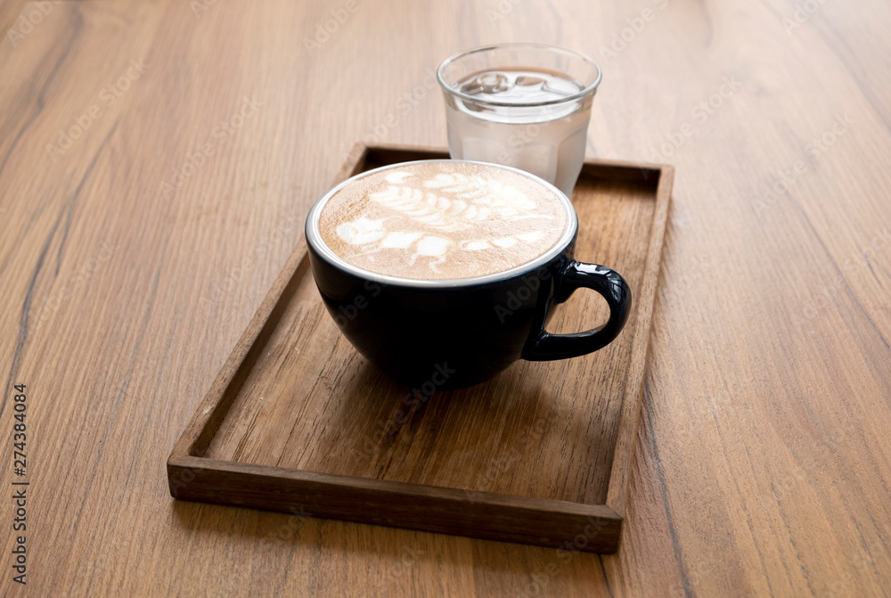 Hot latte with beautiful latte art on the wooden table