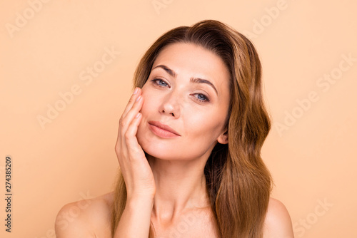 Close up photo beautiful amazing mature she her lady overjoyed after salon spa procedures aesthetic pretty ideal appearance nude arm hand palm touch cheek perfection isolated pastel beige background