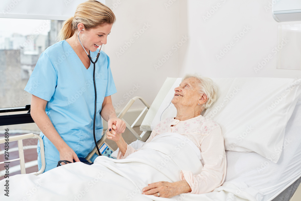 Fototapeta premium Nurse with stethoscope at the bedside