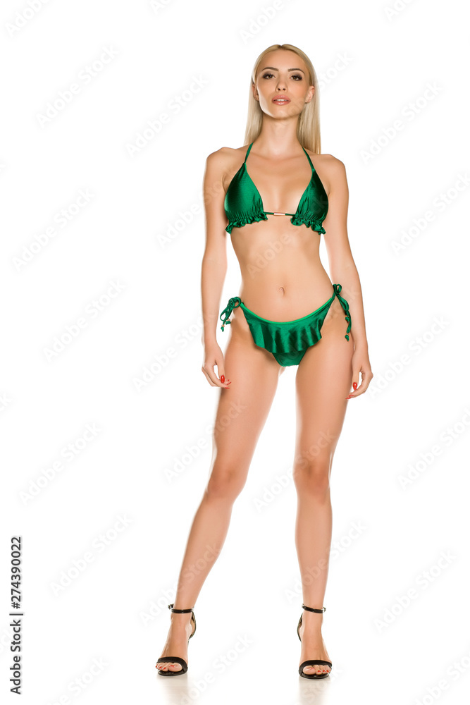 Pretty young lady in green bikini swimsuit and sandals on white background Pretty young lady in green bikini swimsuit and sandals on white background