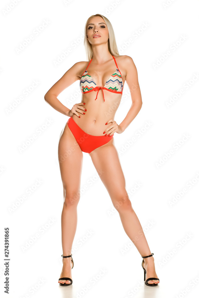 Pretty young lady in red bikini swimsuit and sandals on white background Pretty young lady in red bikini swimsuit and sandals on white background