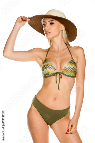 Pretty young lady in green bikini swimsuit and hat on white background
