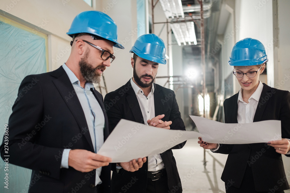 Engineers in hardhats have conversation Engineers in hardhats have conversation