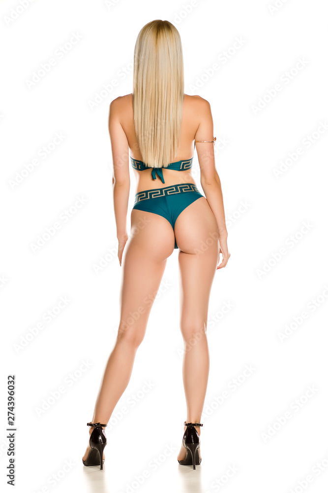 Rear view of pretty young lady in green swimsuit on white background Rear view of pretty young lady in green swimsuit on white background