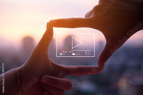 Online live video marketing concept.Photo sign made by human hands on blurred sunset sky as background photo