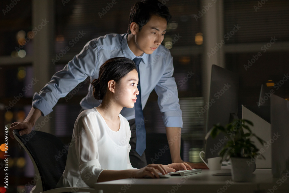 Young business people working late in office