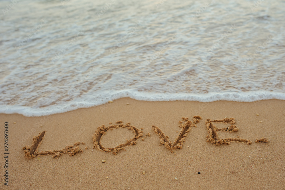 LOVE lettering on the beach with wave and sunlight