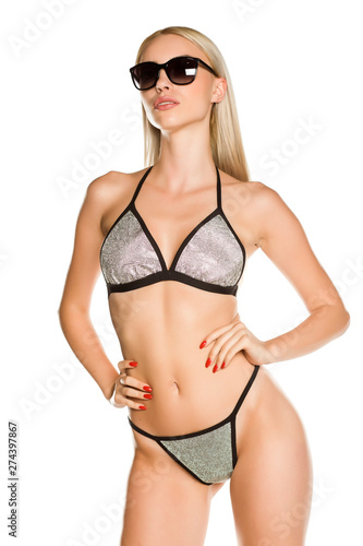 Pretty young lady in silver glittering swimsuit and sunglasses,on white background © Jasmina