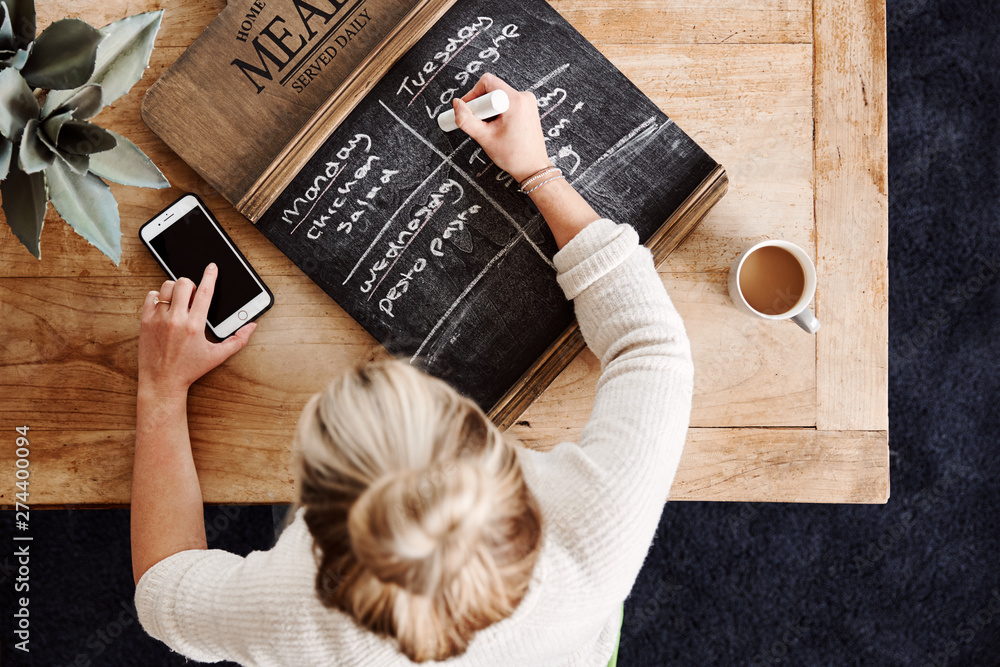 Overhead Shot Looking Down On Woman At Home Writing Meal Plan On Blackborad Overhead Shot Looking Down On Woman At Home Writing Meal Plan On Blackborad