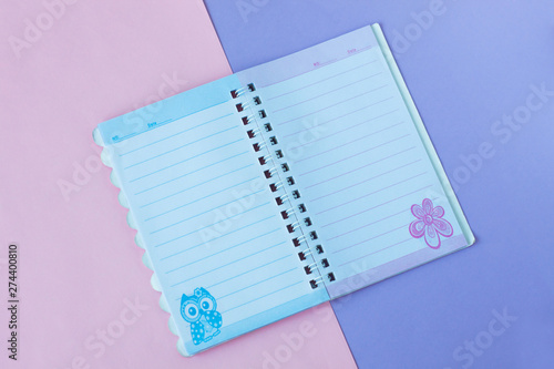 Notebook with lines. School stationery on a pink and purple duotone background. photo