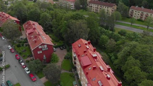 Aerial video of an apartment building with a newly made roof looking very fresh and clean in suburb Orgryte torp in Gothenburg, Sweden, with parked cars standing on the street photo