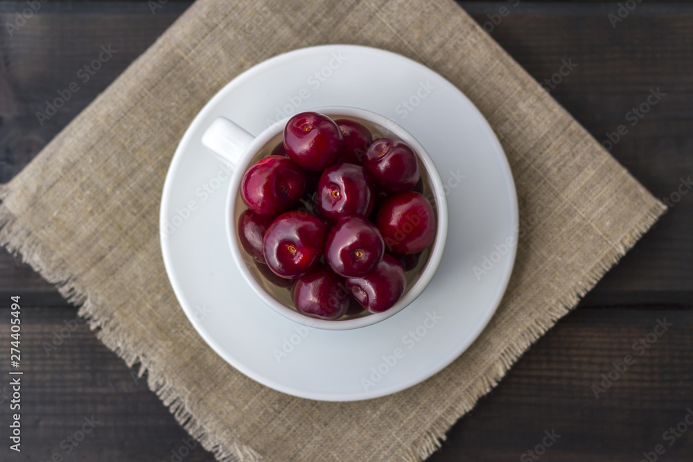 Fresh organic ripe sweet cherry in a white ceramic mug Fresh organic ripe sweet cherry in a white ceramic mug