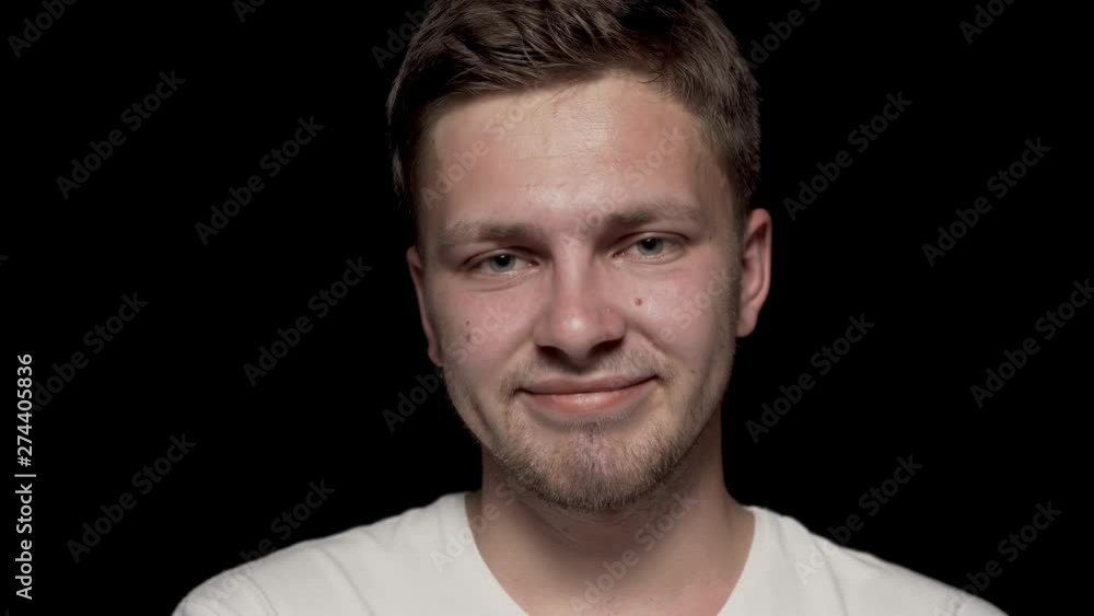 Smiling head of caucasian man looking at camera with arms folded. Black isolated background, white t-shirt. Smiling head of caucasian man looking at camera with arms folded. Black isolated background, white t-shirt.