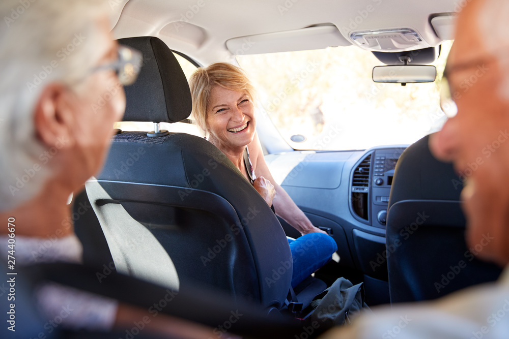 Group Of Senior Friends Sitting In Car Driving To Vacation
