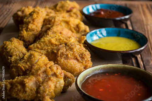 Fried chicken with sauce on a wooden table.