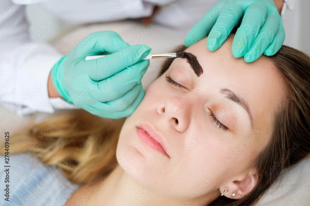 Beautician performing henna brows correction Beautician performing henna brows correction