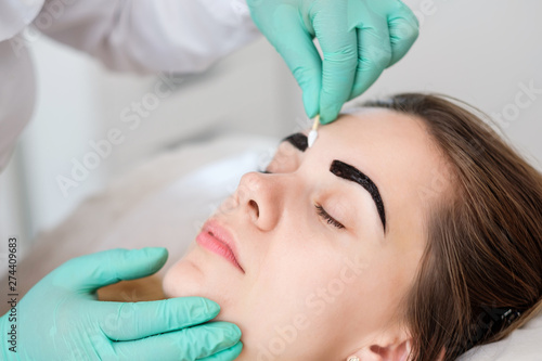 Beautician performing henna brows correction