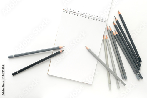 Top view, notebook with pencils on a white background.