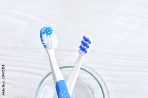 New and used toothbrushes with soft focus on blurred neutral background. Old unhygienic toothbrush and replacement new brush with selective focus. Two brushes for daily morning dental routine 