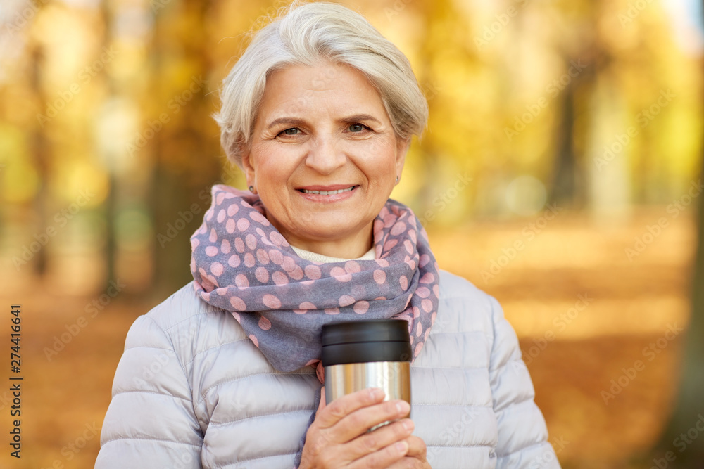 old age, retirement and people concept - close up of happy senior woman at autumn park drinking coffee or tea from tumbler mug old age, retirement and people concept - close up of happy senior woman at autumn park drinking coffee or tea from tumbler mug