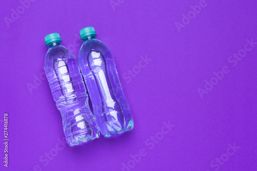 Water bottle flat lay top view on color paper background
