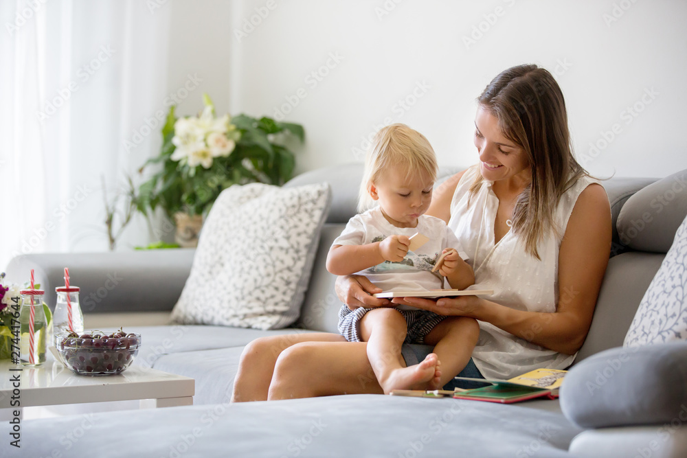 Charming mother, making puzzle with her cute toddler baby boy at home Charming mother, making puzzle with her cute toddler baby boy at home