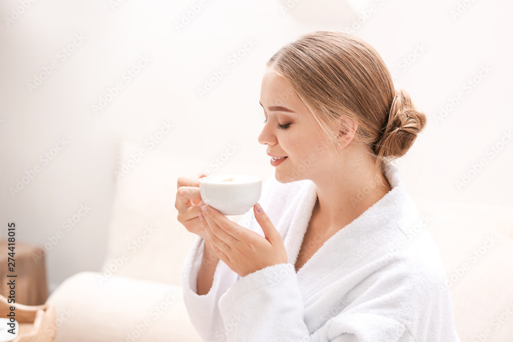 Beautiful young woman drinking coffee in spa salon Beautiful young woman drinking coffee in spa salon