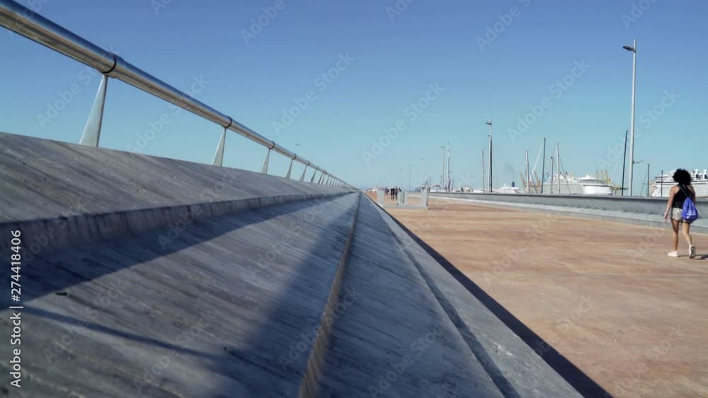 Metallic bars and concrete in Barcelona's port. Blue sky and calm water. Sea. Ships are on the background. Horizontal line. Summer Metallic bars and concrete in Barcelona's port. Blue sky and calm water. Sea. Ships are on the background. Horizontal line. Summer