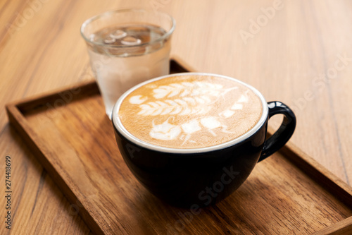 Hot latte with beautiful latte art on the wooden table