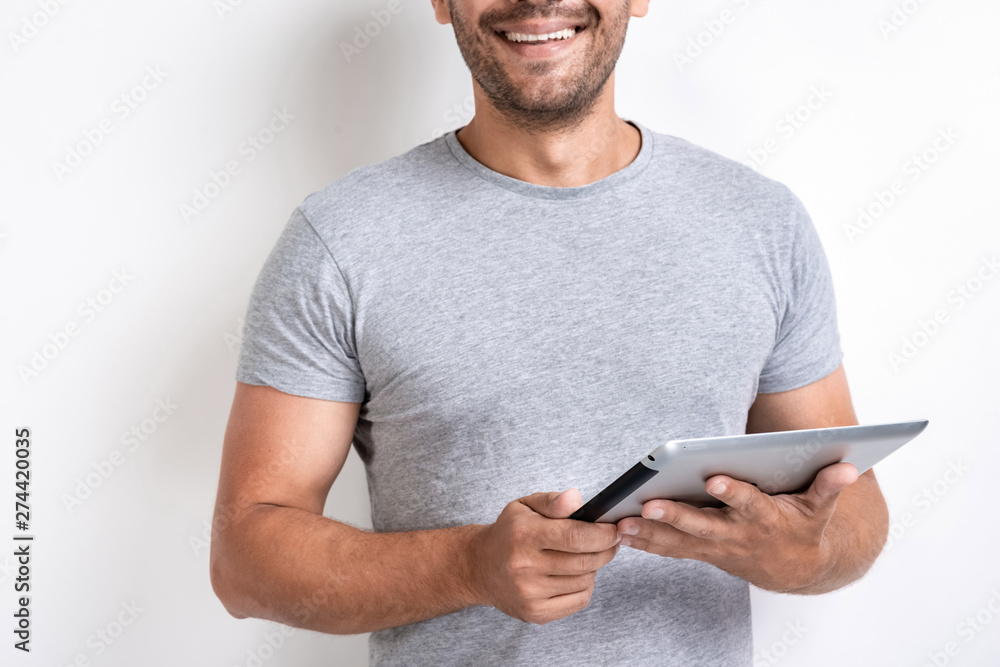 Smiling man holding ipad in his hands. - Cropping image Smiling man holding ipad in his hands. - Cropping image