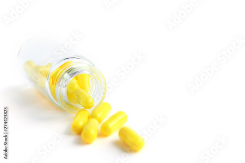 Yellow capsules from glass bottle on white background. copyspace for text. Epidemic  painkillers  healthcare  treatment pills and drug abuse concept