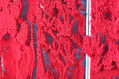 Abstract red background of contact interactive wall made of plastic sticks