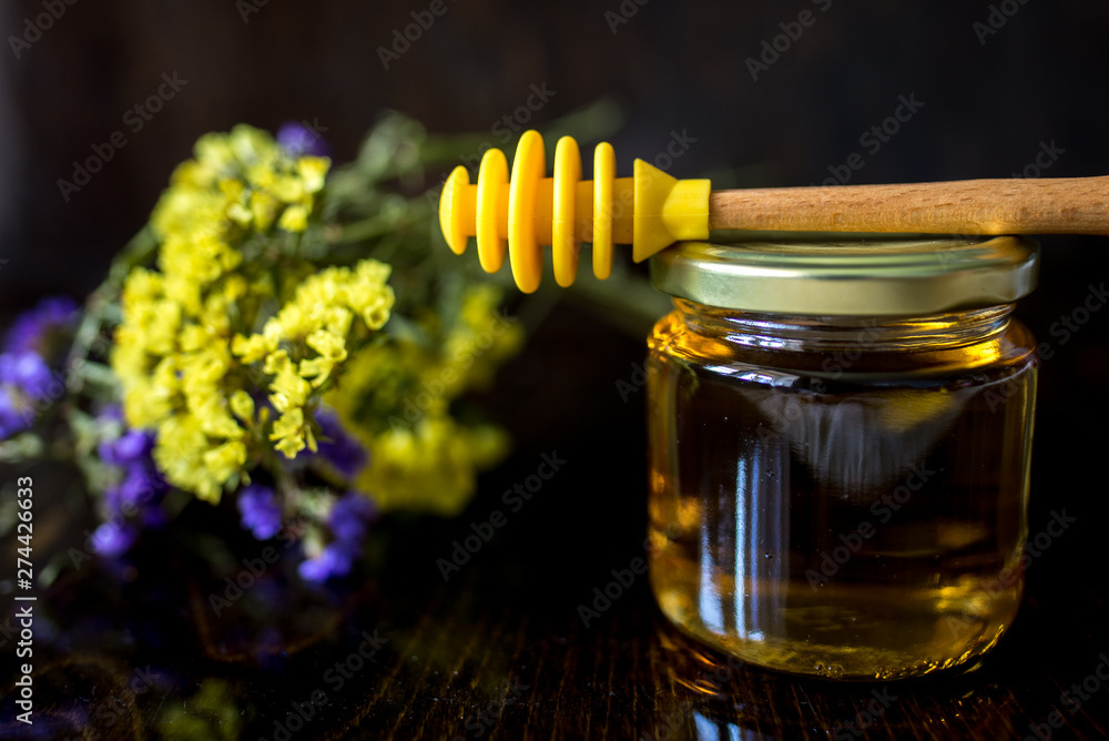gold honey in glass jar with dipper gold honey in glass jar with dipper