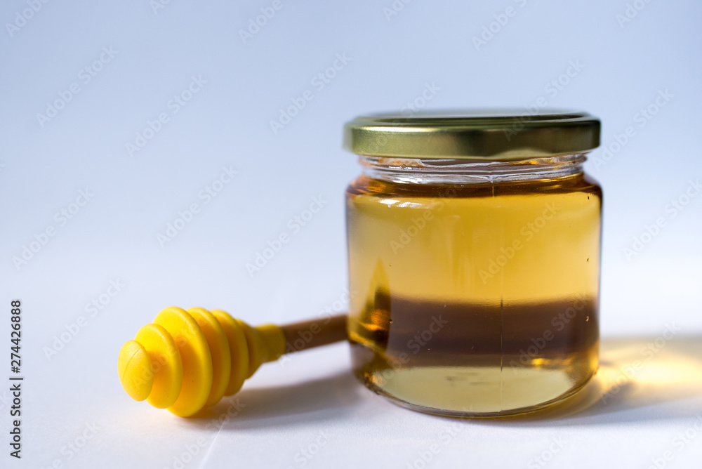 honey in glass jar with wooden dipper honey in glass jar with wooden dipper