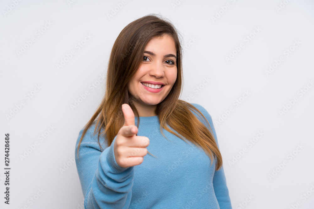 Young girl with blue sweater points finger at you Young girl with blue sweater points finger at you